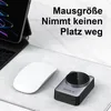 A white mouse and a black and silver charging device are placed on a light gray mousepad next to a laptop. Produktbild-Vorschau