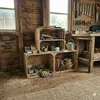 A rustic workshop interior with wooden crates used for storage and display of tools and household items. Produktbild-Vorschau