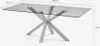 A rectangular glass-top dining table with a unique cross-shaped base, shown from a three-quarter side view against a plain light gray background. Dimensions are indicated. Anteprima dell’immagine prodotto