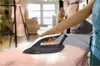 A person's hand is holding an iron over a pink fabric on an ironing board, with steam rising from the iron. Voir les images du produit