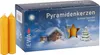 A box of pyramid candles with two candles in front of it, set against a snowy winter scene. Produktbild-Vorschau