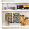 A white shelf displaying various ceramic dishes and jars of pasta. Náhled obrázku produktu
