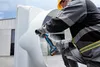 A person is using a cordless angle grinder on a large white object. Náhľad obrázku produktu