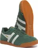 A pair of green Gola Harrier Suede sneakers with white stripes and brown soles, shown from a slightly angled front view with one shoe in the foreground and the other behind it. Produktbild-Vorschau