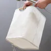 A person is rinsing a white laundry basket under a shower head. Náhľad obrázku produktu