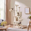 A multi-level cat tree with several platforms, a basket, a hammock, and a tunnel, occupied by three Siamese cats. The cat tree is placed in a living room setting with a window, curtains, a chair, a coffee table, and a rug. Podgląd zdjęcia produktu