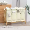 A multi-compartment laundry basket with a bamboo frame, shown in a room setting with a dresser and plant. Anteprima dell’immagine prodotto