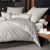 A neatly made bed with a grid-patterned duvet cover and pillows. Voir les images du produit