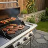 A barbecue grill with food cooking on it in a backyard setting. Anteprima dell’immagine prodotto