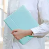 A person holding a light blue tablet case. Náhľad obrázku produktu