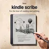 A hand is shown writing on a Kindle Scribe device, which displays a drawing and text. The background is a textured wall. Náhľad obrázku produktu
