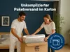 A couple is packing a mattress into a cardboard box in a bedroom. Produktbild-Vorschau