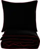 A black duvet cover and pillowcase set with red trim, neatly folded and stacked against a white background. Náhľad obrázku produktu