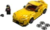 A yellow LEGO Speed Champions Toyota GR Supra car with a minifigure and extra wheels. Náhled obrázku produktu
