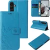 A collage of images showing a blue flip phone case with floral and butterfly designs from multiple angles, including its interior card slots and how it functions as a stand. Produktbild-Vorschau