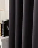 A close-up view of dark gray curtains with books and a lamp in the background. Produktbild-Vorschau