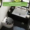 A bathroom scene featuring a toilet with a decorative seat and a sink. Podgląd zdjęcia produktu