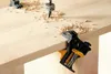 A drill bit is drilling into a wooden surface, with wood shavings scattered around. Corner clamps are used to hold the wood in place. Anteprima dell’immagine prodotto