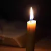 A single lit candle in a dark setting. Podgląd zdjęcia produktu
