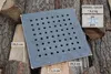 A square metal grate with holes is placed on a pile of chopped wood. Voir les images du produit