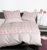 A neatly made bed with pillows and a duvet cover featuring a circular pattern. Produktbild-Vorschau