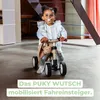A young child is riding a Puky Wutsch balance bike indoors, with a stuffed bunny attached to the handlebars. Anteprima dell’immagine prodotto