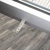 A flat satellite window feedthrough is shown installed on a wooden floor next to a sliding door frame. Produktbild-Vorschau