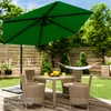 A patio set with a large green umbrella, table, and chairs, set in a backyard with a hammock in the background. Produktbild-Vorschau