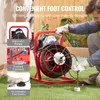 A man is using a pipe cleaning machine outdoors on grass. Podgląd zdjęcia produktu