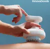 Hands using a white massage device on a person's leg. Anteprima dell’immagine prodotto
