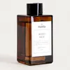 A brown glass reed diffuser bottle with a white label and a black cap, set against a white background. Náhľad obrázku produktu