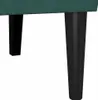 A close-up view of the bottom part of a dark green sofa, showing two black legs. Podgląd zdjęcia produktu