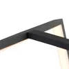 A close-up shot of a black geometric frame with a soft, warm light emanating from behind it. Náhľad obrázku produktu