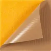 A close-up view of an orange acoustic panel with a brown backing sheet being peeled away. Podgląd zdjęcia produktu