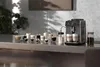 A Saeco automatic espresso machine is shown on a countertop with various coffee cups and a jar of coffee beans. Produktbild-Vorschau