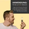 A man is holding a small bottle of pheromone spray and looking at it. Produktbild-Vorschau