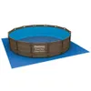 An above-ground swimming pool with a blue interior and a brown woven exterior, placed on a blue ground tarp. Produktbild-Vorschau