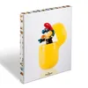A Smurf figure pops out of a yellow Kinder Egg-like capsule, presented on a white background. Produktbild-Vorschau