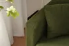 A close-up view of a green textured sofa armrest and a cushion. Anteprima dell’immagine prodotto