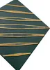 A close-up, angled view of a dark green wall panel with raised gold stripes. Produktbild-Vorschau