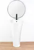 A white pedestal sink with a black faucet and a round mirror above it, set against a white wall and a wooden floor. Podgląd zdjęcia produktu