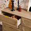 A close-up view of a wooden dresser with rattan-style drawer fronts, one drawer is partially open. Anteprima dell’immagine prodotto