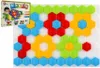 A mosaic toy kit with hexagonal pieces arranged in a flower pattern, next to its packaging. Produktbild-Vorschau