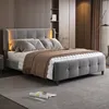 A modern bedroom with a gray upholstered bed as the main focus, featuring integrated LED lighting and a brown throw blanket. Náhľad obrázku produktu