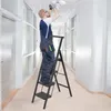 A man is standing on a ladder changing a light fixture in a hallway. Voir les images du produit