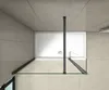 A top-down view of a modern shower enclosure with a white shower tray, glass panels, and dark metal framing, set against tiled walls and floor. Produktbild-Vorschau