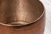A close-up view of a hammered copper table. Produktbild-Vorschau