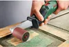 A hand is holding a Bosch sander and using it to sand a wooden surface. Podgląd zdjęcia produktu