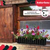 A black planter box filled with colorful petunias sits on a windowsill below a wooden shuttered window. Produktbild-Vorschau