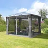 A gazebo set up in a garden with furniture inside. Podgląd zdjęcia produktu